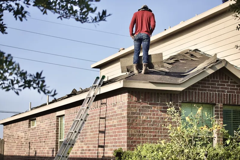 Professional roofer working on a residential roof in West Duxbury